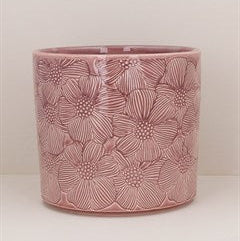Pink ceramic pot with floral patterns on a white background