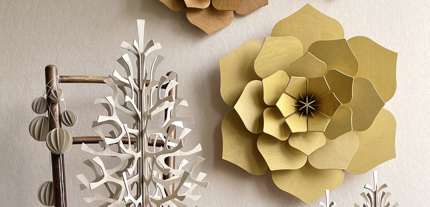 Decorative paper trees and flowers on a neutral background